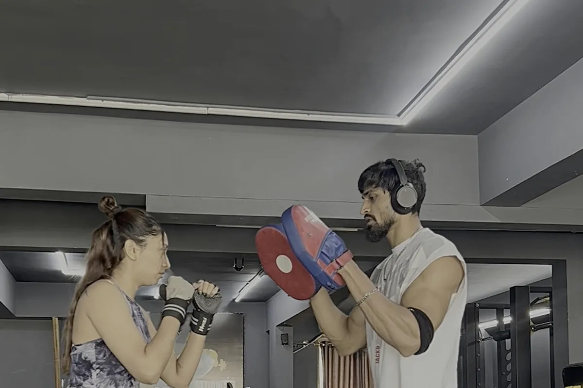 Coach Meet coaching a client through pad work at Transformation HQ